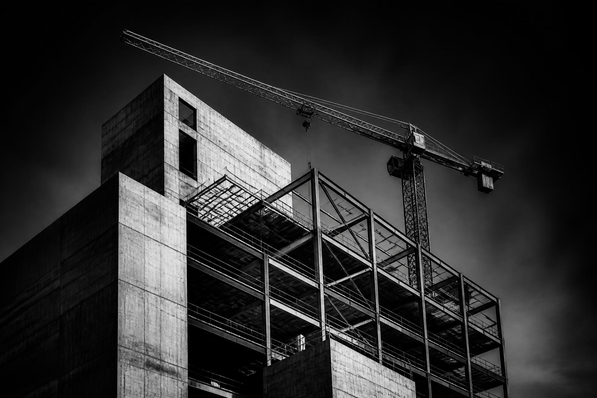 Edifício em construção com guindaste, em preto e branco